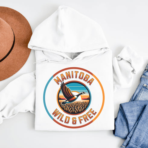 Celebrate the heart of the prairies with our Manitoba – Wild & Free hoodie, featuring a stunning graphic of a Canadian goose soaring over golden wheat fields.